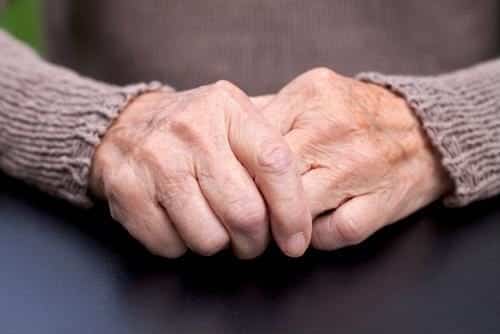 a close up an elderly woman's hands one clasping the other