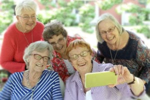 Group of senior women smiling and posing for a photograph.