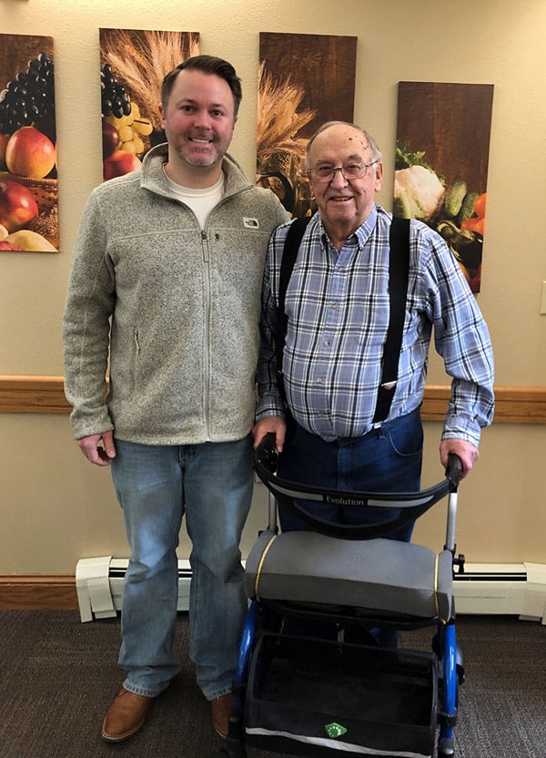 Edgewood employee Brendan Weidler standing to the left of his grandfather, resident Harold Weidler