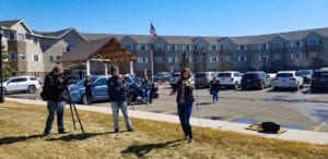 Female violinist Kelsey Buell performing on the grass outside the Edgewood Healthcare independent living community in Fargo