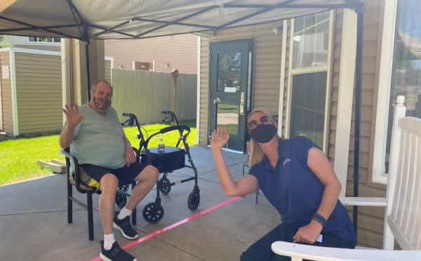 Edgewood Sierra Hills resident Dave Bryant and his daughter Shellee Reynolds visit from a safe distance on a patio outside his home.