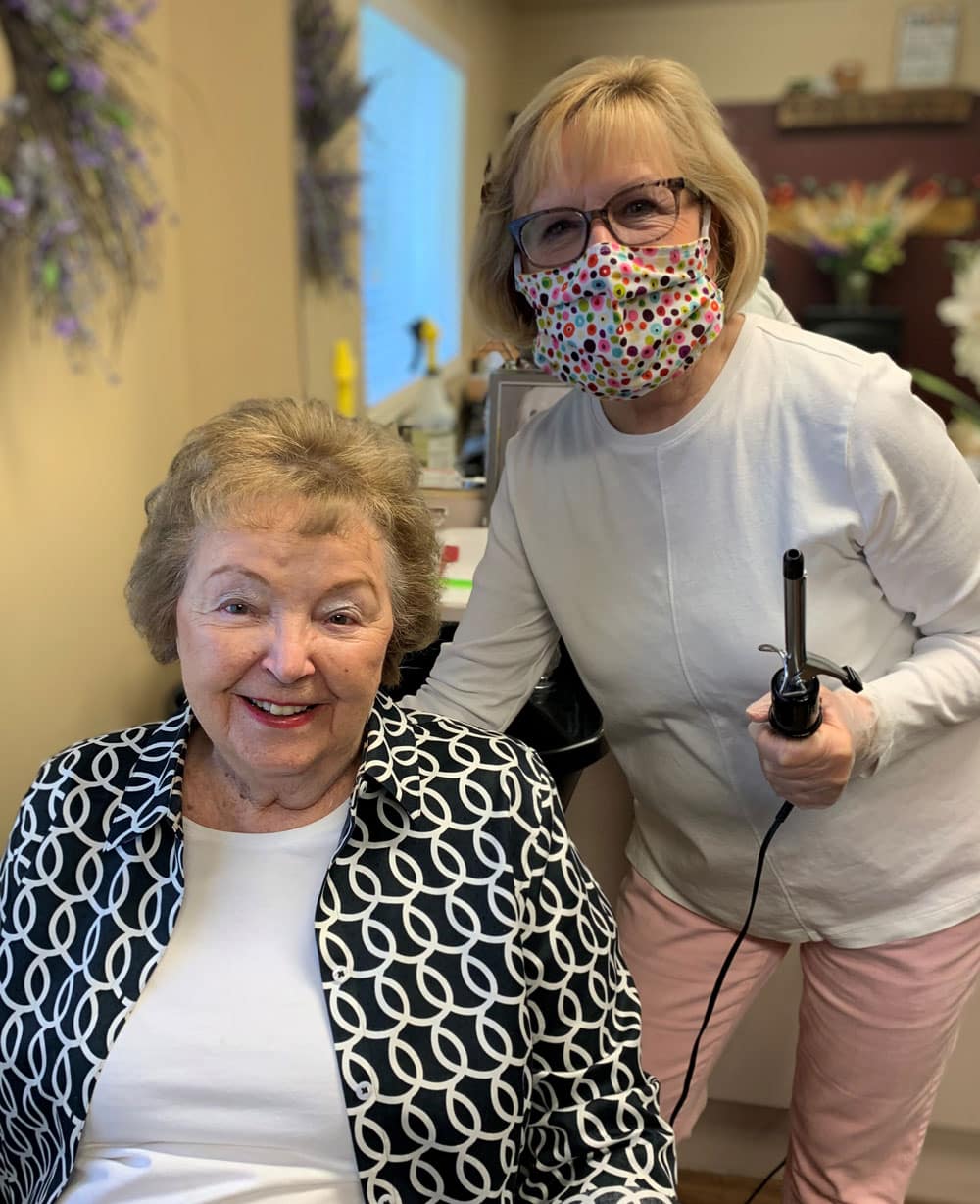 Senior Edgewood Healthcare resident Shirley Bodmer and female employee Mary Ann Murdoch pose for a photo together in the company’s hair salon in Boise, ID.