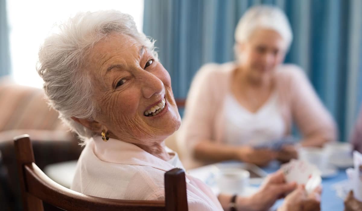 Close up of women playing cards together, while still socially distant.