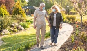 Two people walking outdoors while holding hands.