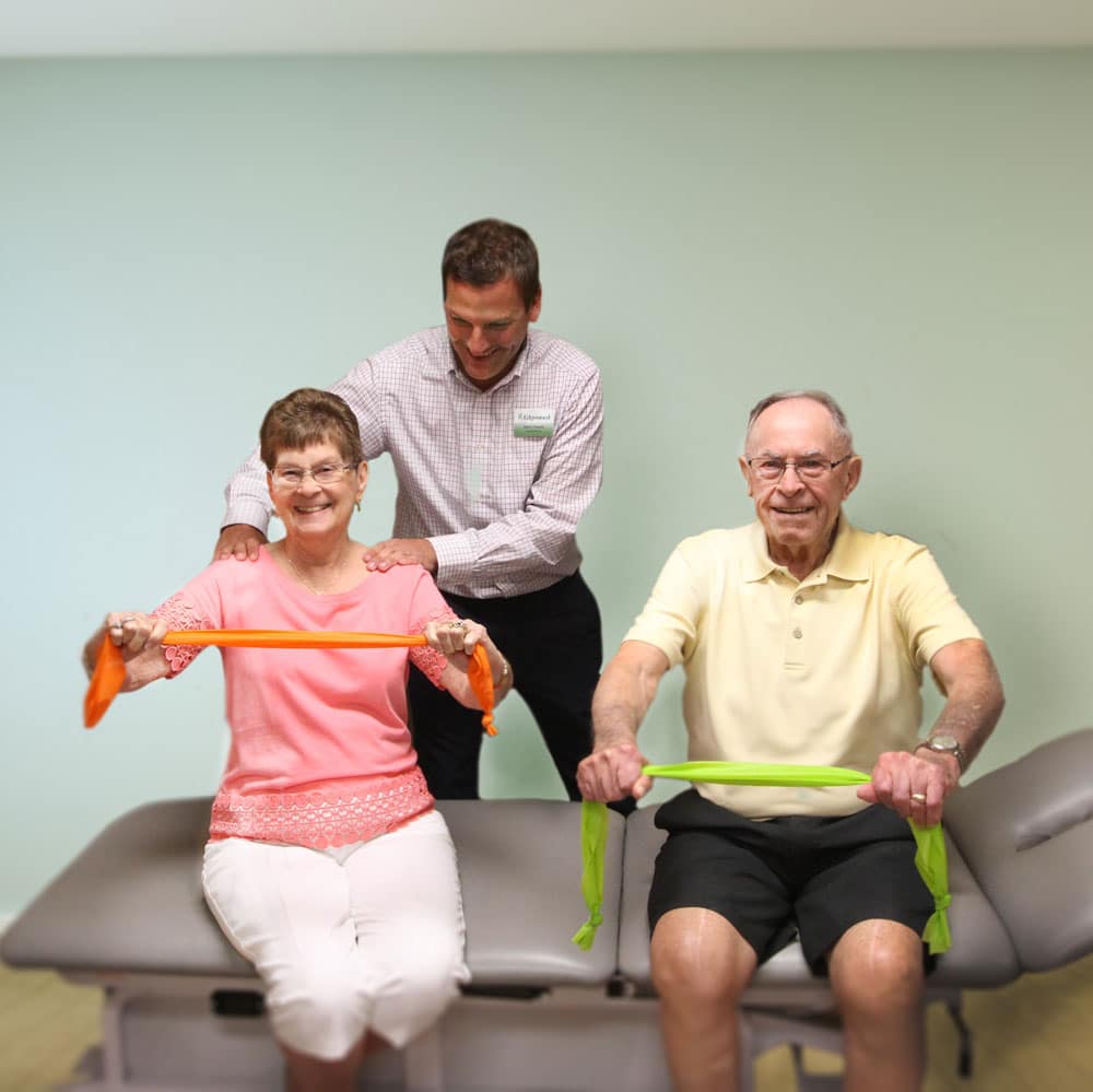Couple-Physical-Therapy Older couple doing physical movement with therapy bands.