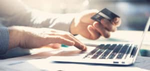 A closeup of a man making an online payment with a credit card