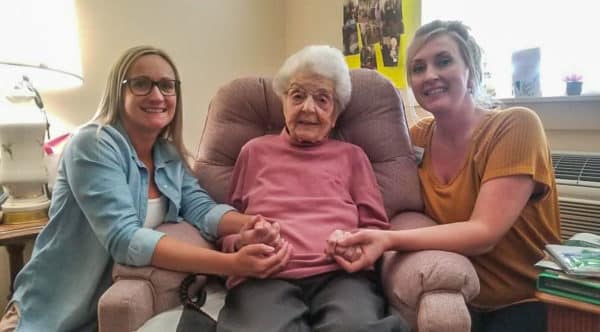 A female senior resident of Edgewood Healthcare poses for a photo with two female nurses