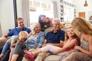 family with female and male senior laughing seated on couch