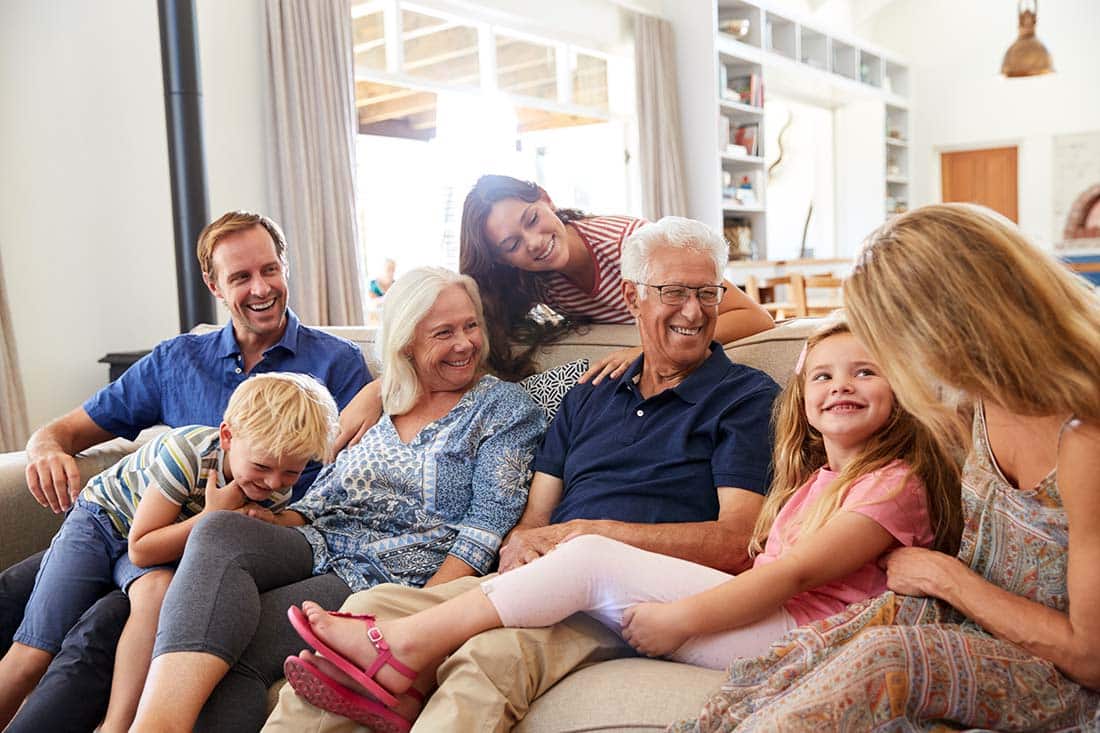 family with female and male senior laughing seated on couch