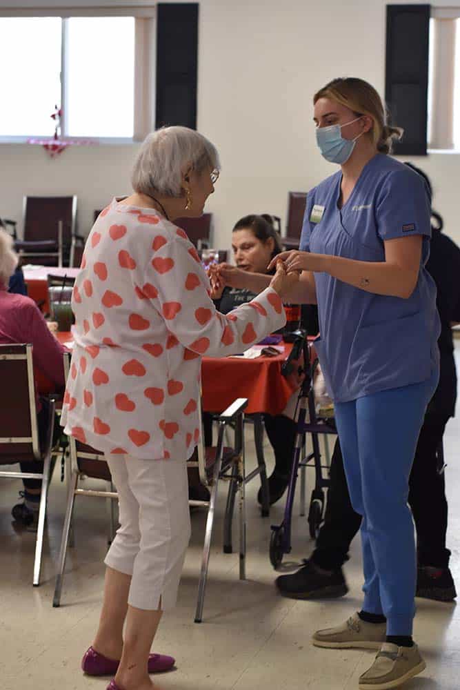 Edgewood employee dancing with a senior resident in a community