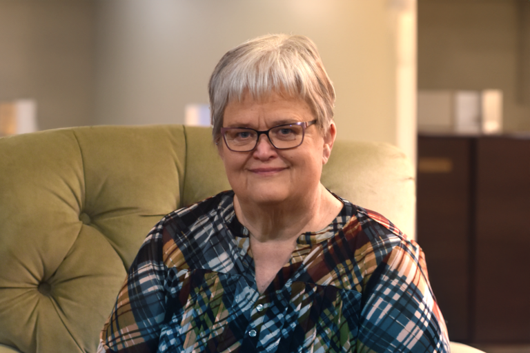 a 55 year old female sitting on a chair