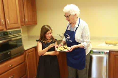 Senior female and female child with plate of cookies