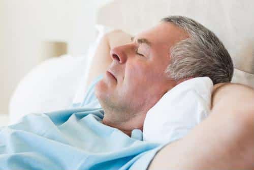 Male sleeping with arms under head
