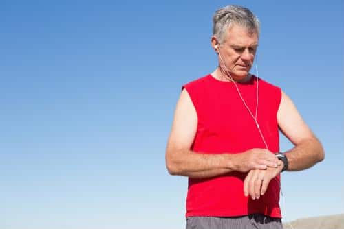 Male wearing headphones looking at wrist