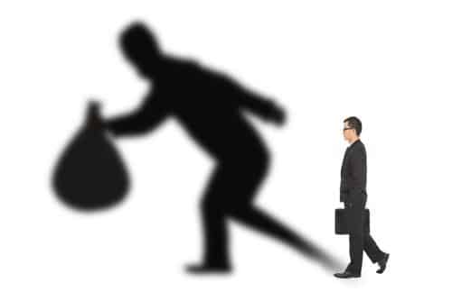 Man holding briefcase and shadow of man holding bag