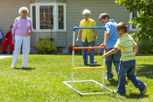 Senior females playing ladder golf with two boys