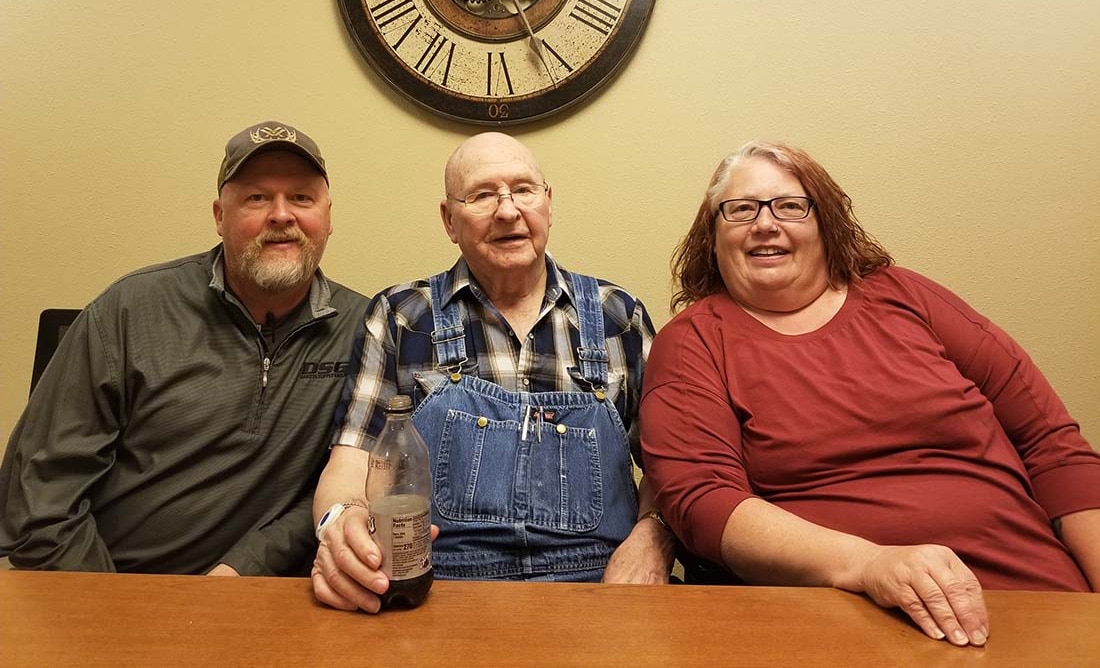 Male seated left of senior male with female to his right