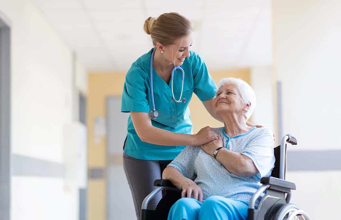 Female clinician next to female senior seated in wheelchair
