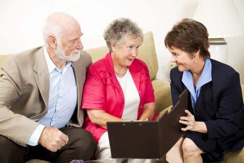 Male and female senior being shown document by female