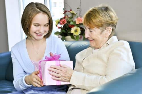 Senior and child holding gift with pink wrapping paper