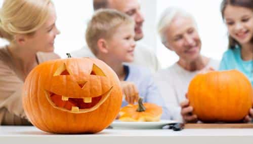 Group of people near pumpkin and jack-o-lantern