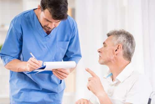 Male in scrubs next to seated male