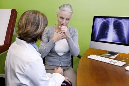 Computer image of chest xray next to coughing female and clinician