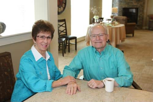 Senior couple wearing teal having coffee