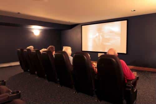 Group of seniors seated in front of a big screen in a movie theater