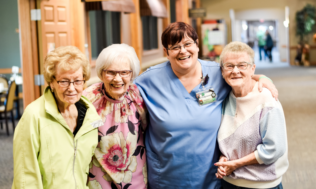 nurse and three senior residents hugging