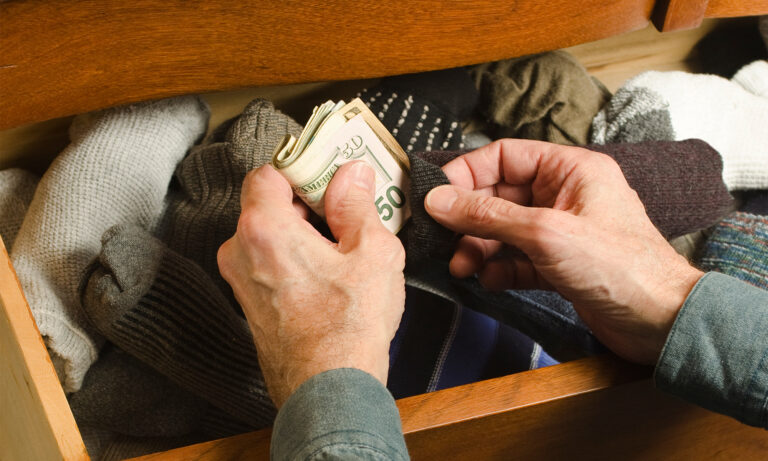 Image of hand and money inside of a sock drawer