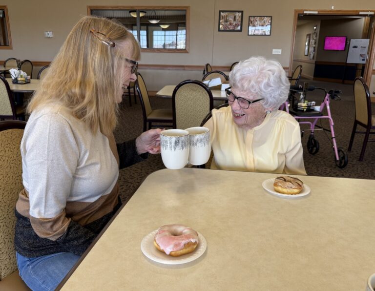two females doing a coffee cheers