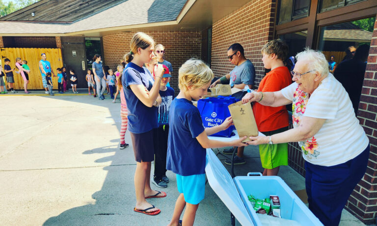 residents handing bags to children