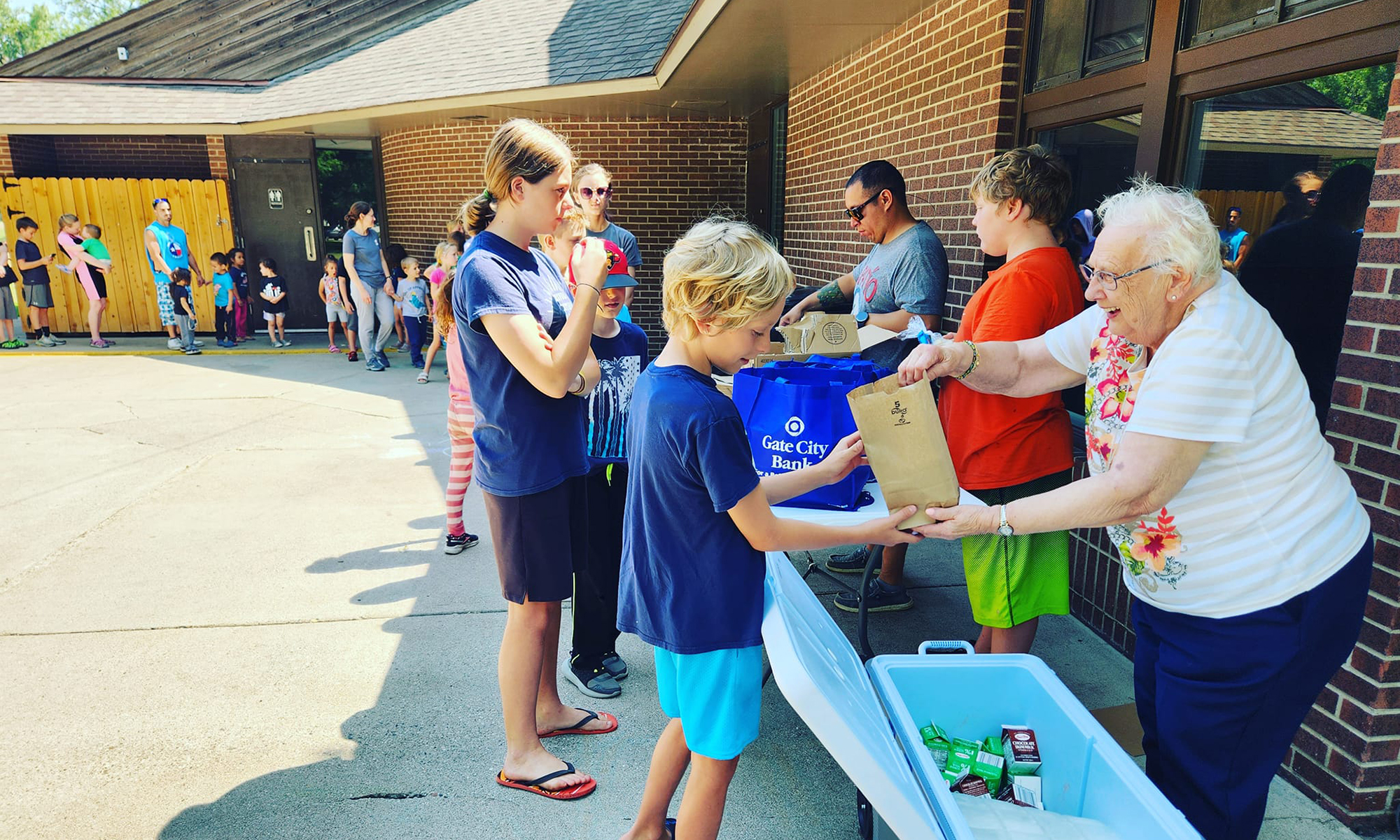 residents handing bags to children