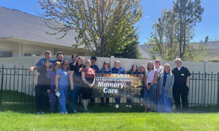 Edgewood Boise team members stand together outdoors with a Boise Favorites 2025 Memory Care winner sign, celebrating their Gold Award for Best Memory Care.