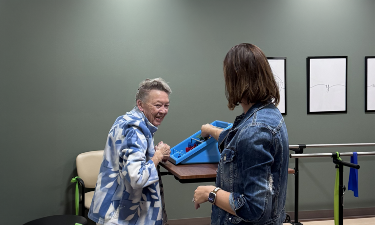 Older woman working with a physical therapist during a therapy session.